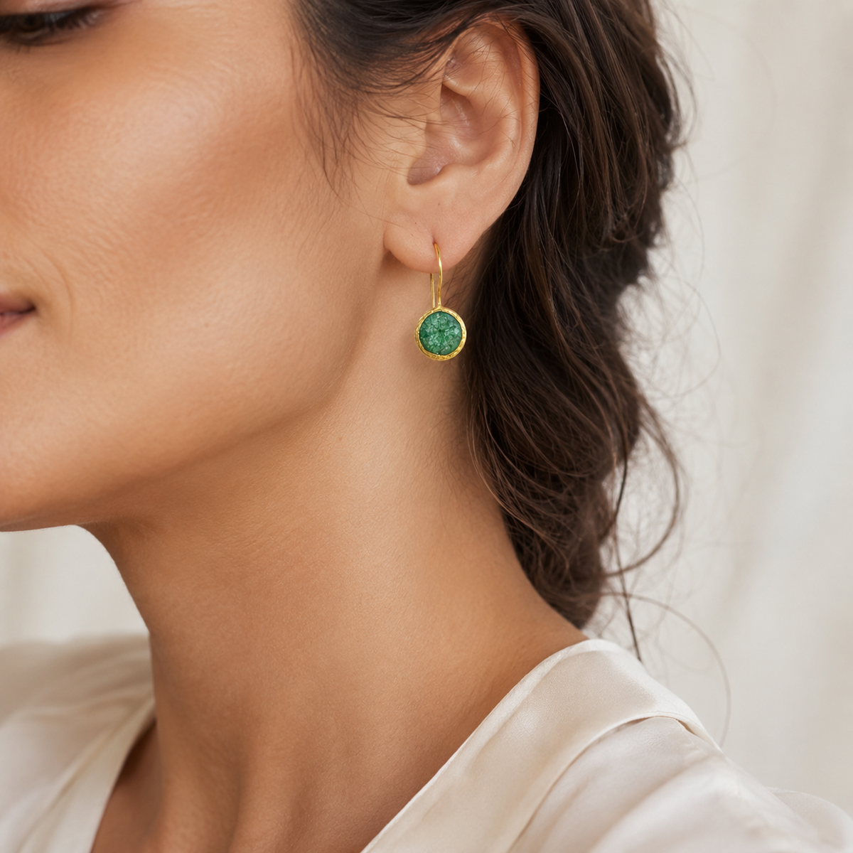 Gold-plated drop earrings with textured round green stones.
