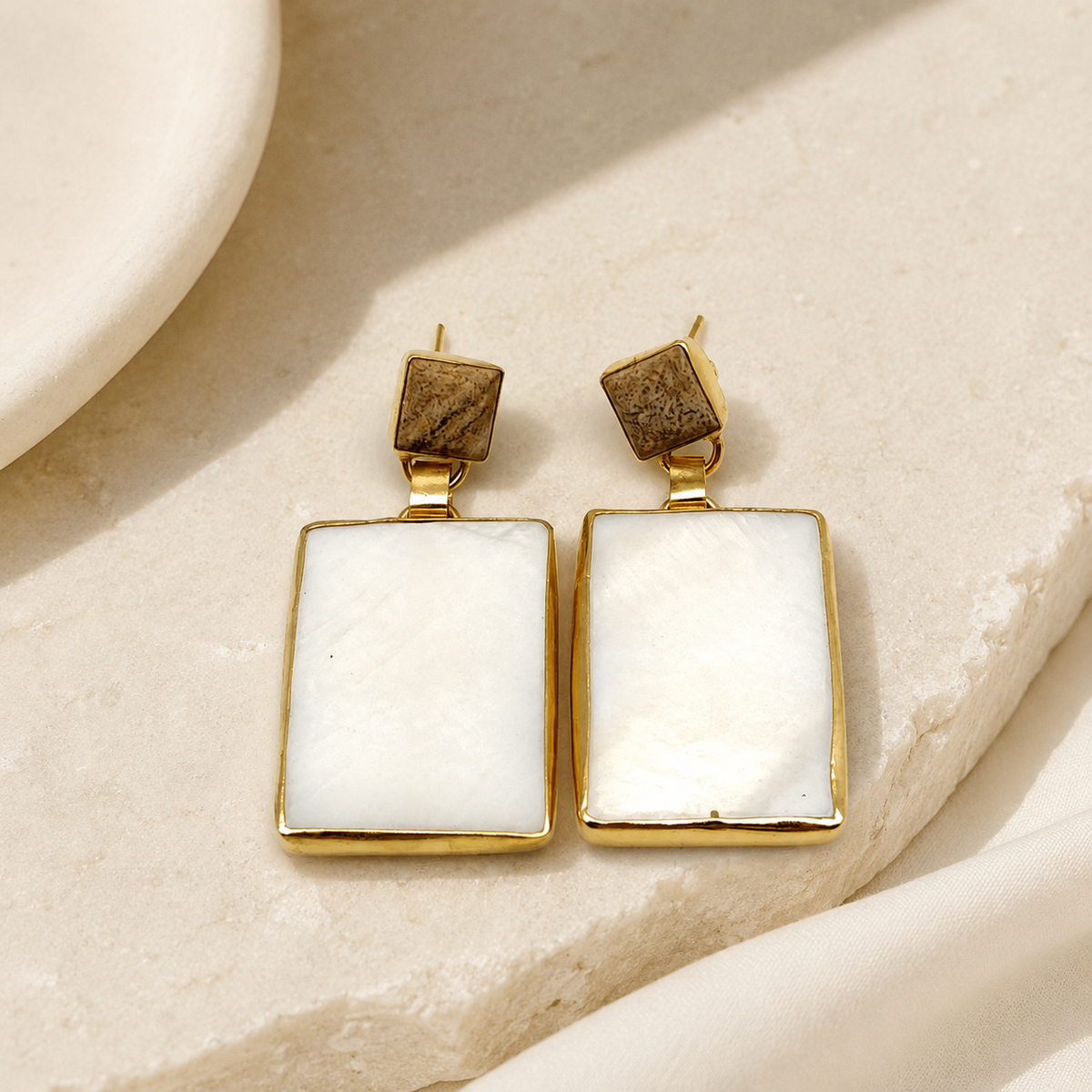 Heart stud earrings with black onyx centers and a warm gold-tone finish.
