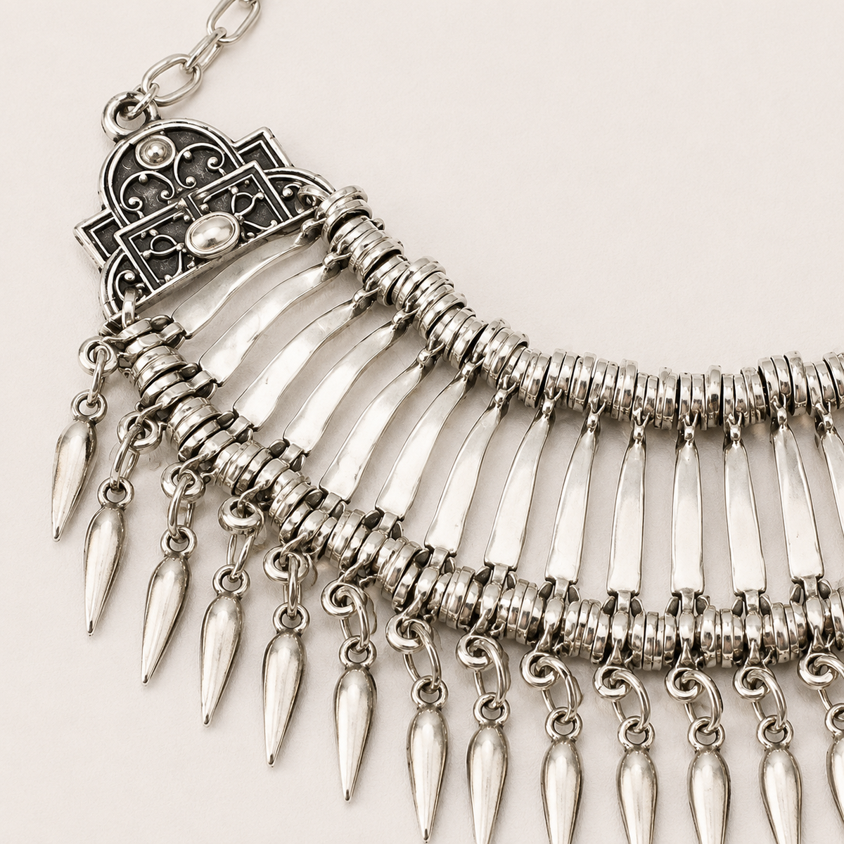 Close view of the silver-tone fan collar necklace with teardrop dangles.