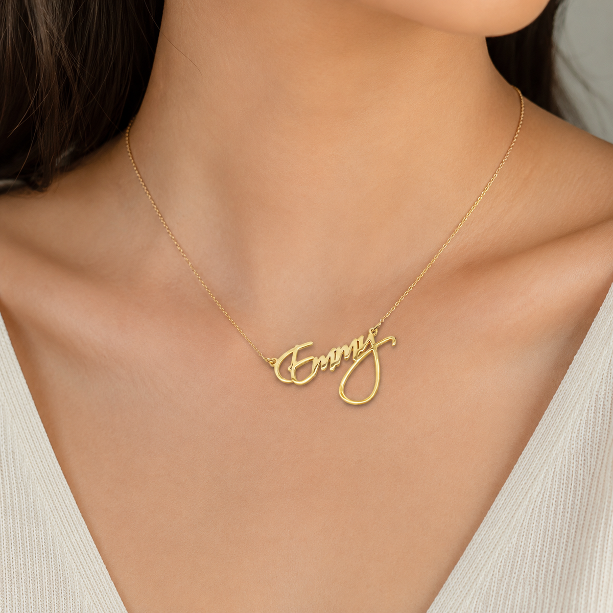 Gold-tone personalized name necklace shown on a white background.