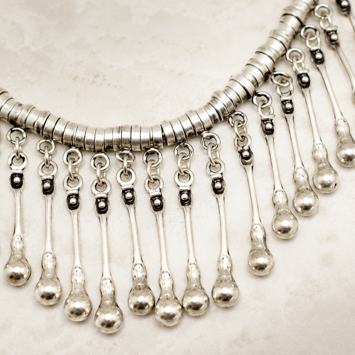 Close view of the silver-tone chain and fringe detail.