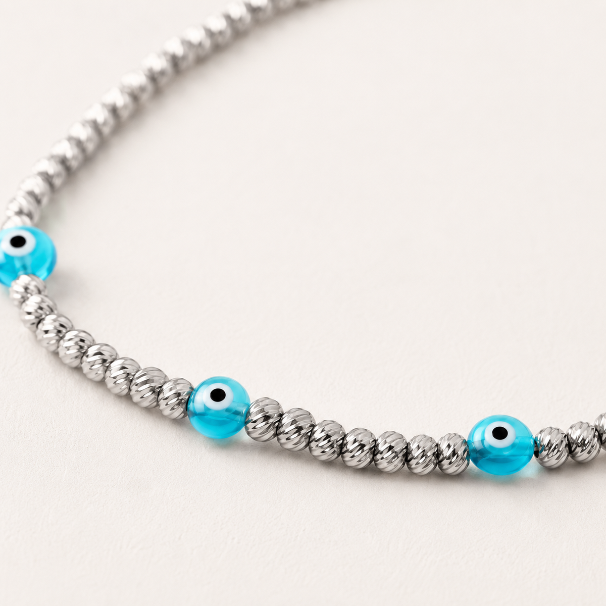 Close view of the silver-tone beads and blue eye accents on the bracelet.