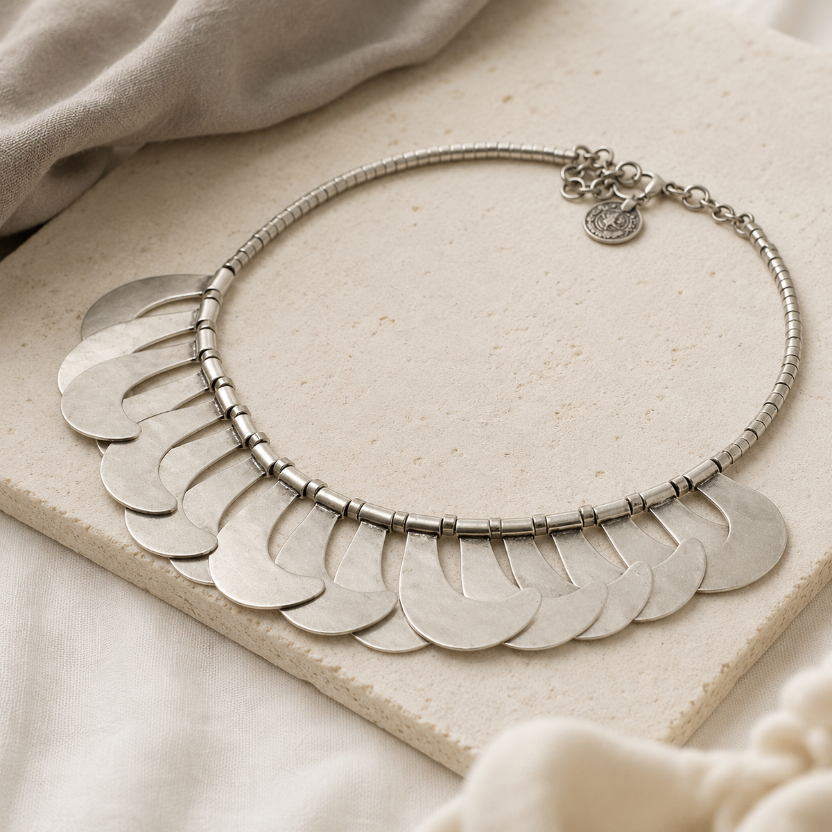 Angled view of a silver-tone crescent scale collar necklace.