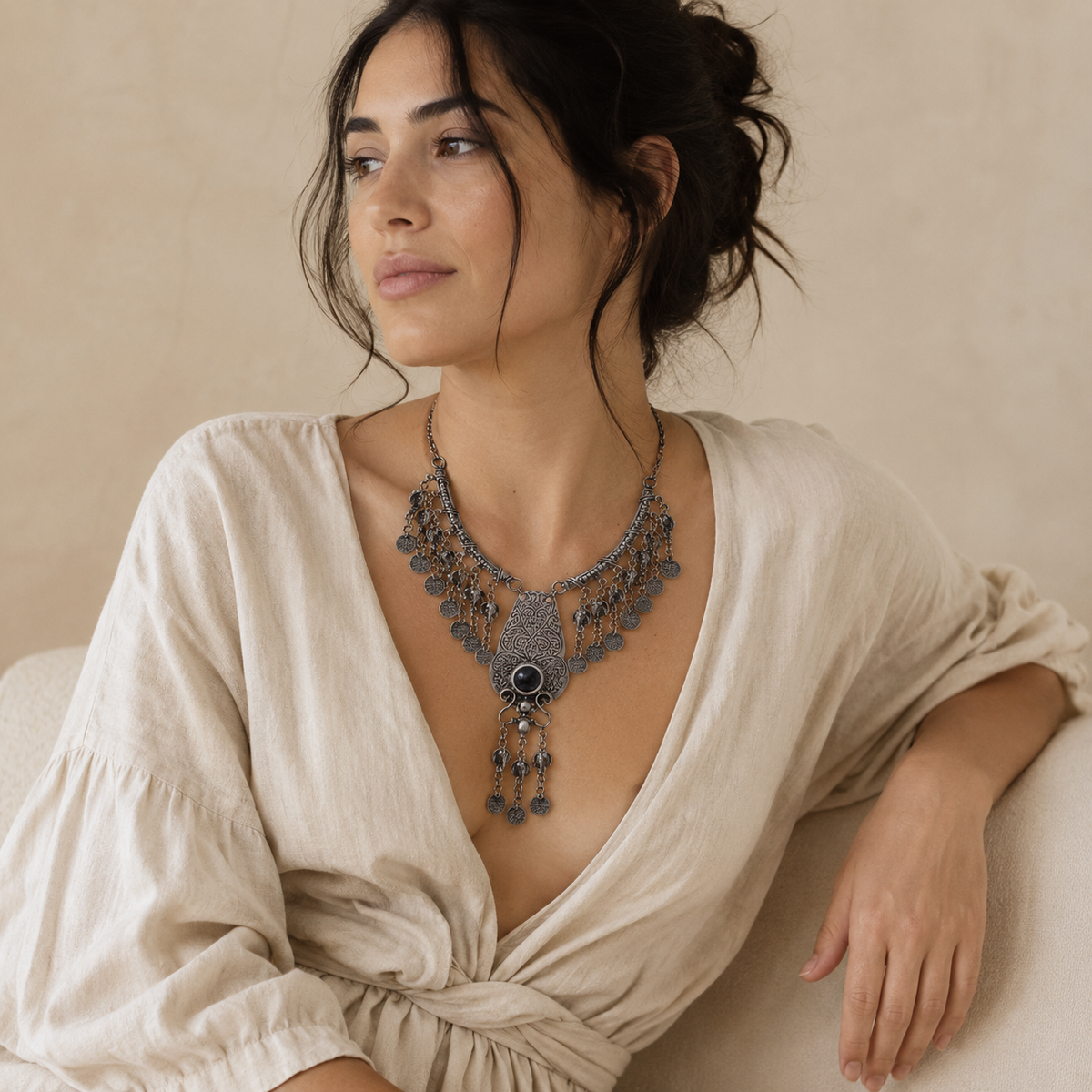 Statement necklace with filigree metalwork, a red stone center, and coin fringe.