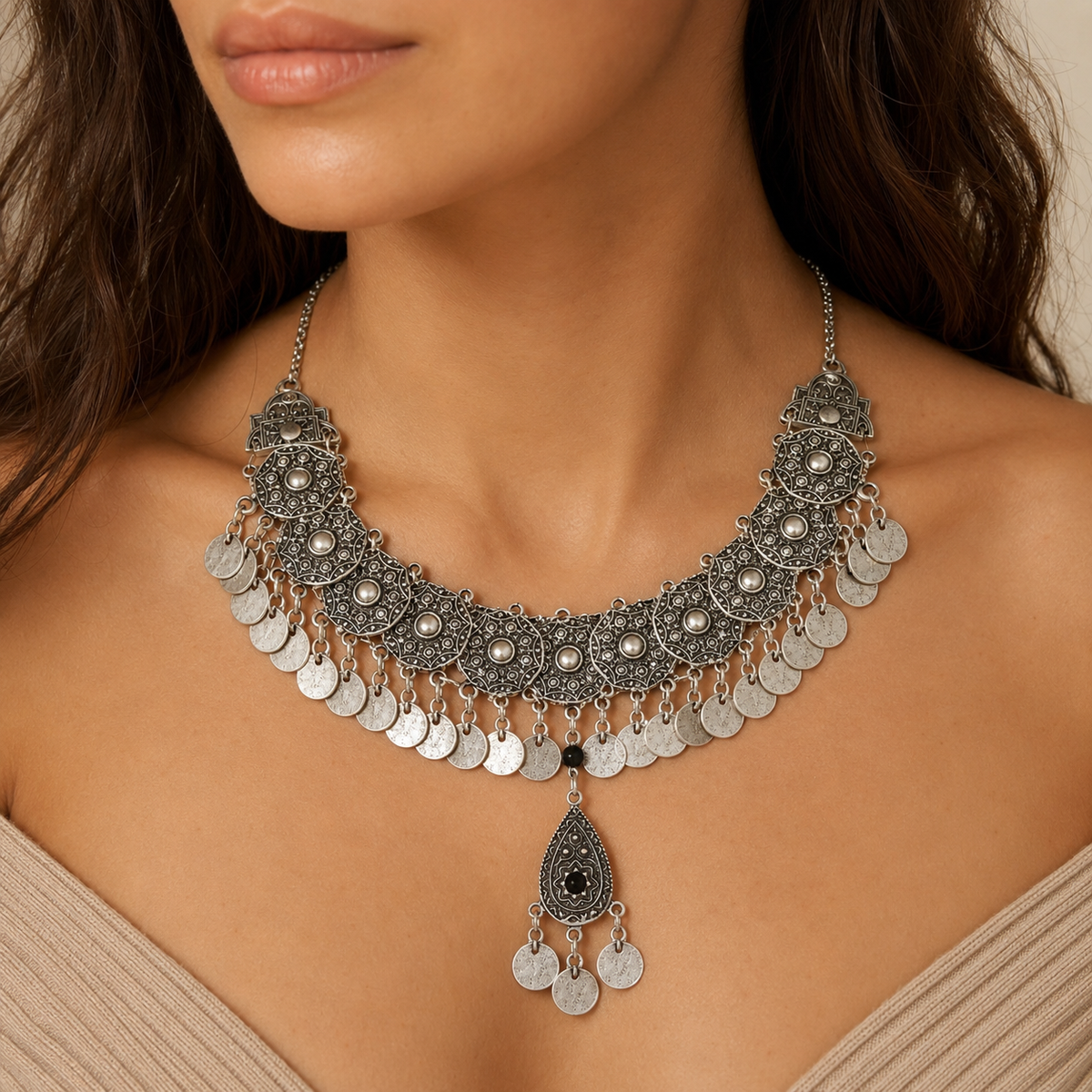 Silver-tone bib necklace with black stone accents and coin fringe shown from the front.