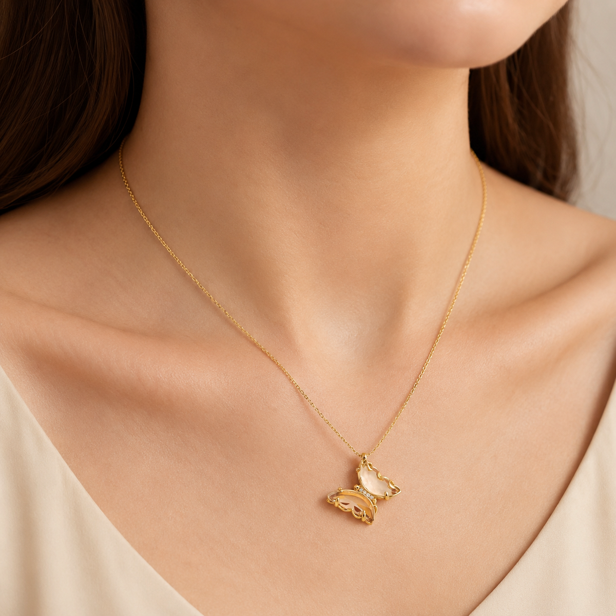 Gold plated butterfly necklace shown on a model.