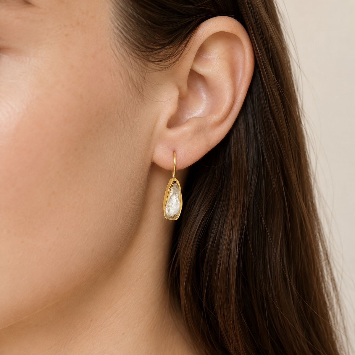 Clear quartz gold-plated hook earrings shown front view on a white background.