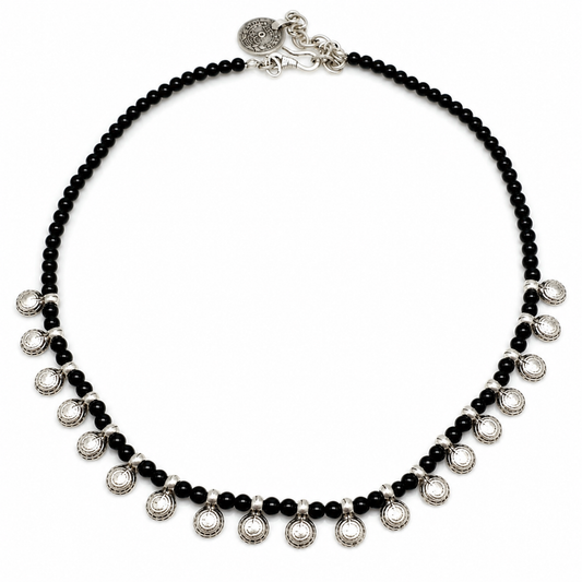 Black bead necklace with round silver-tone charms on a white background.