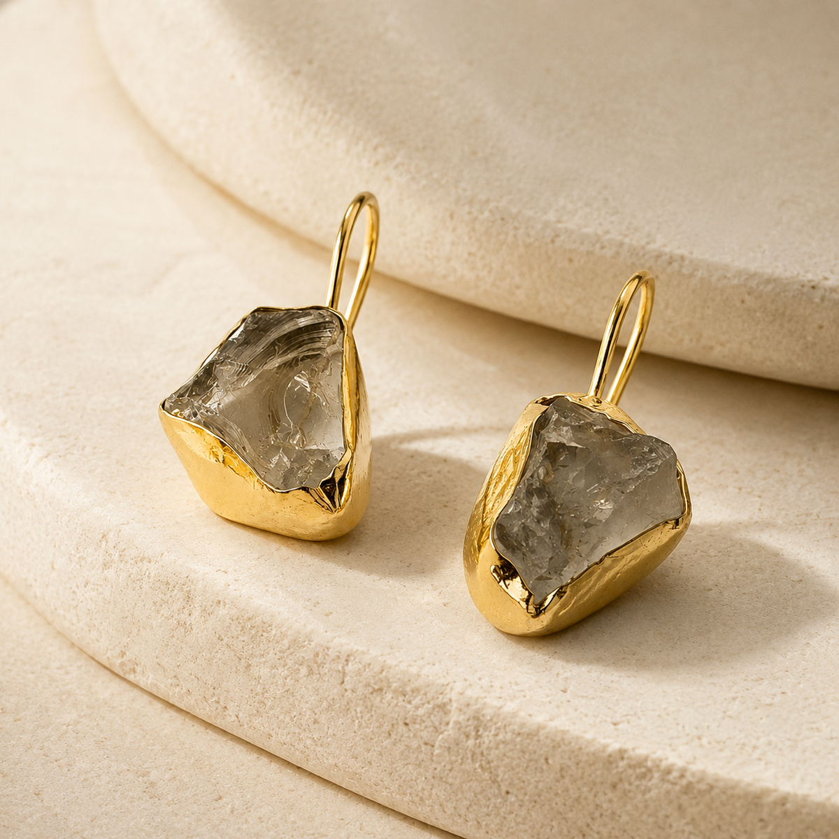Angle view of raw amethyst drop earrings with a gold-plated setting.