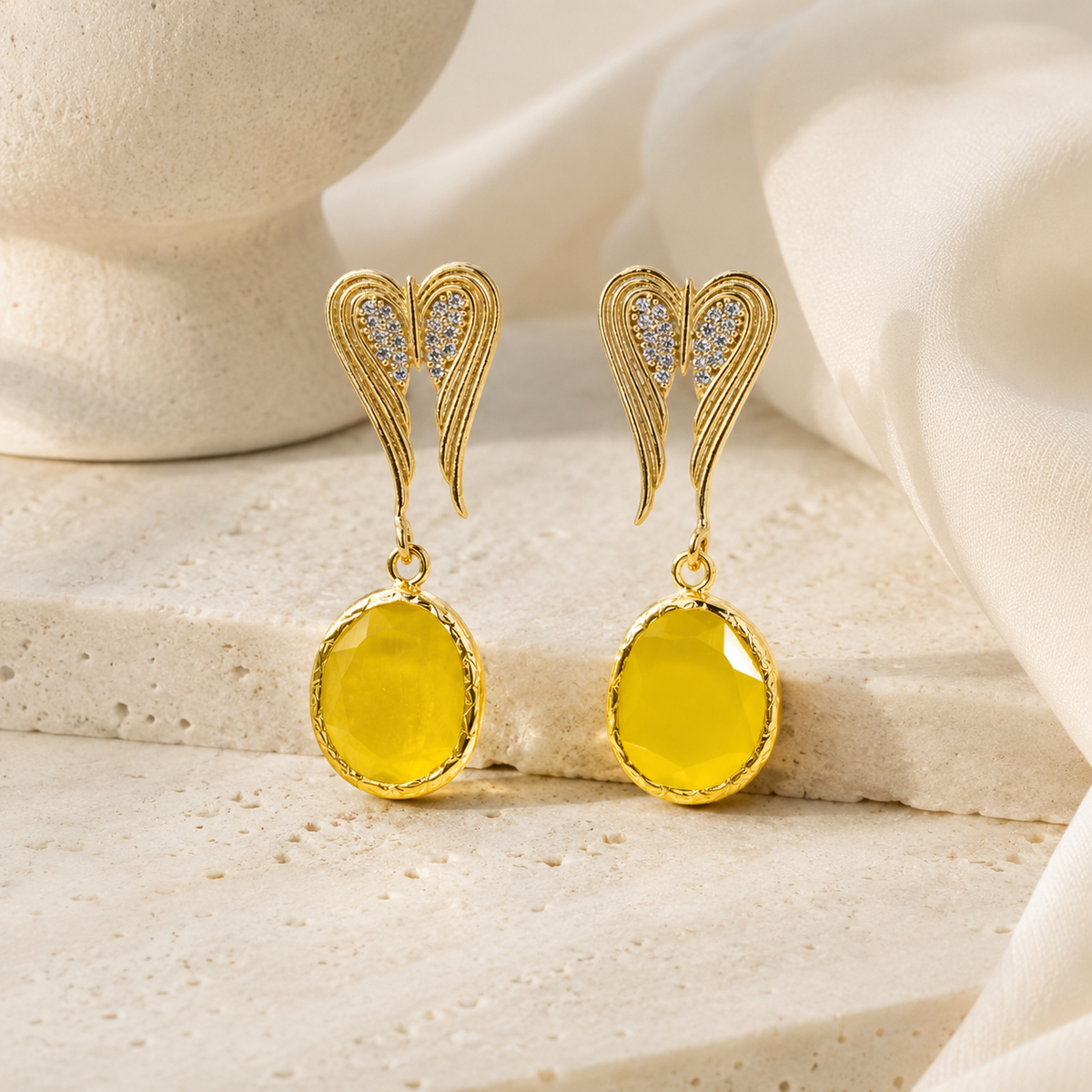 Pair of gold-tone heart dangle earrings on a white background.