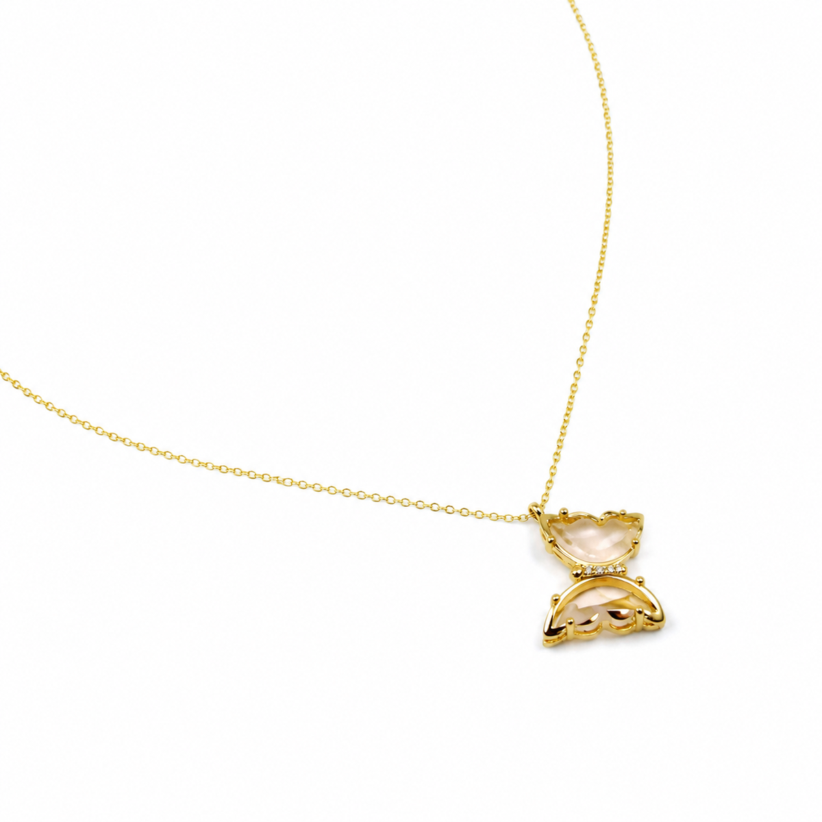 Angled view of a pink glass butterfly pendant necklace in gold-tone metal.