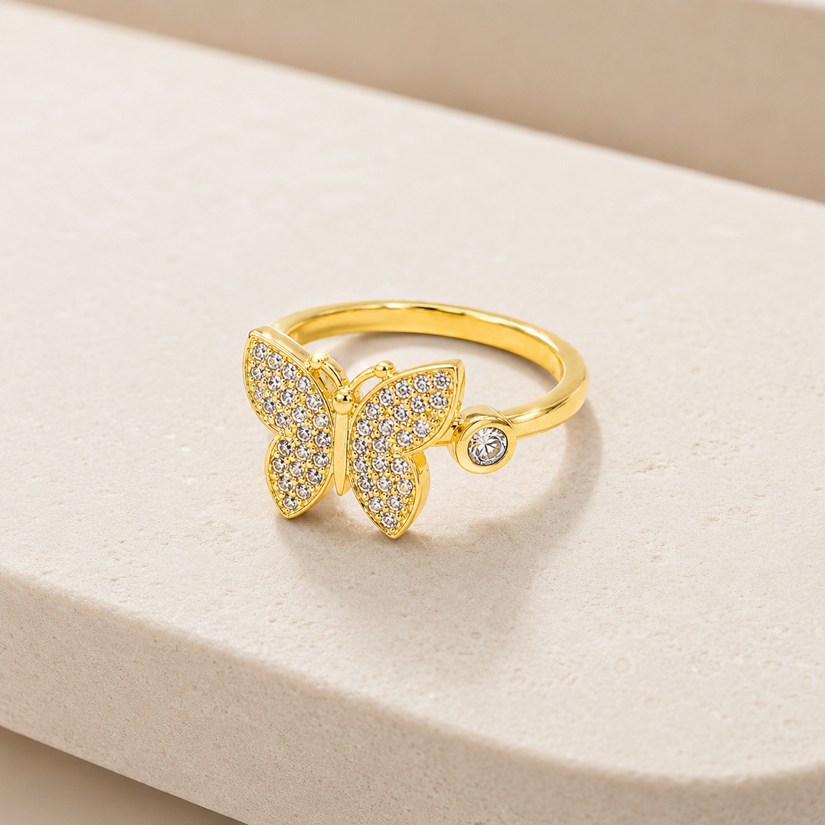 Angled view of a butterfly statement ring with gold-plated shine and CZ details.
