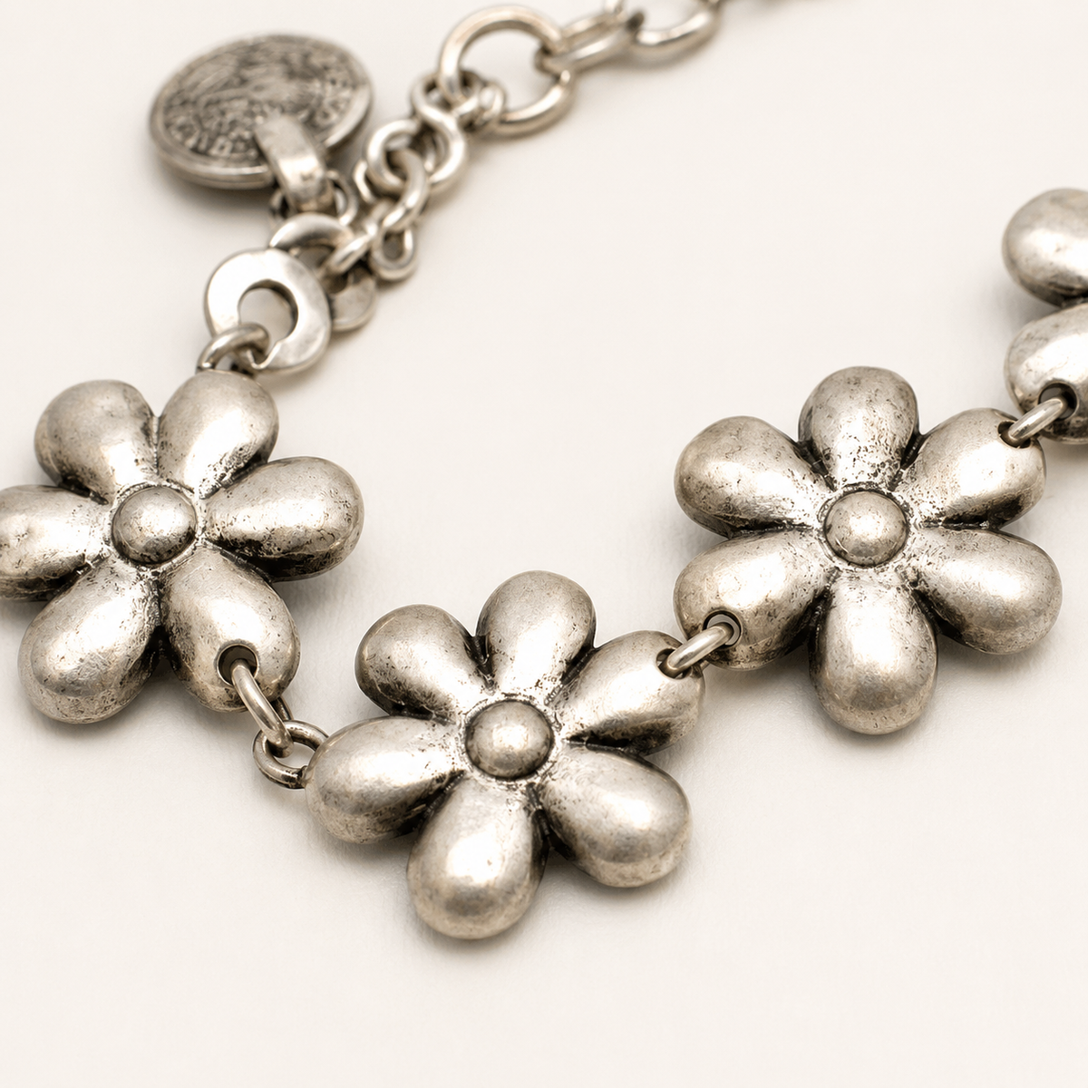 Close view of the silver-tone flower links and textured chain details.