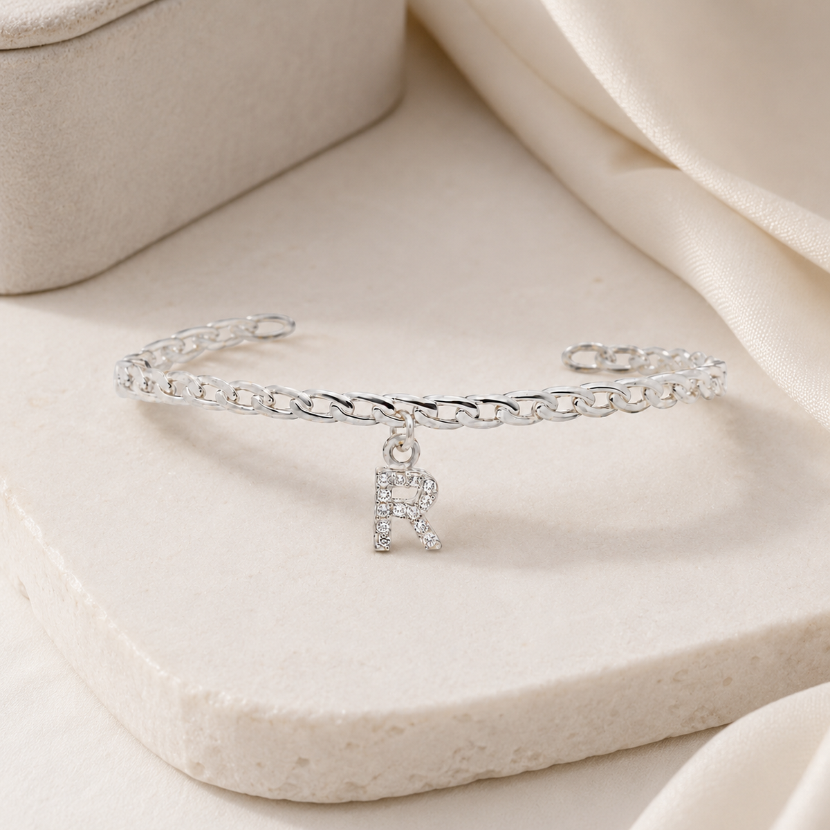Personalized silver-tone cuff bracelet with a sparkling initial detail.