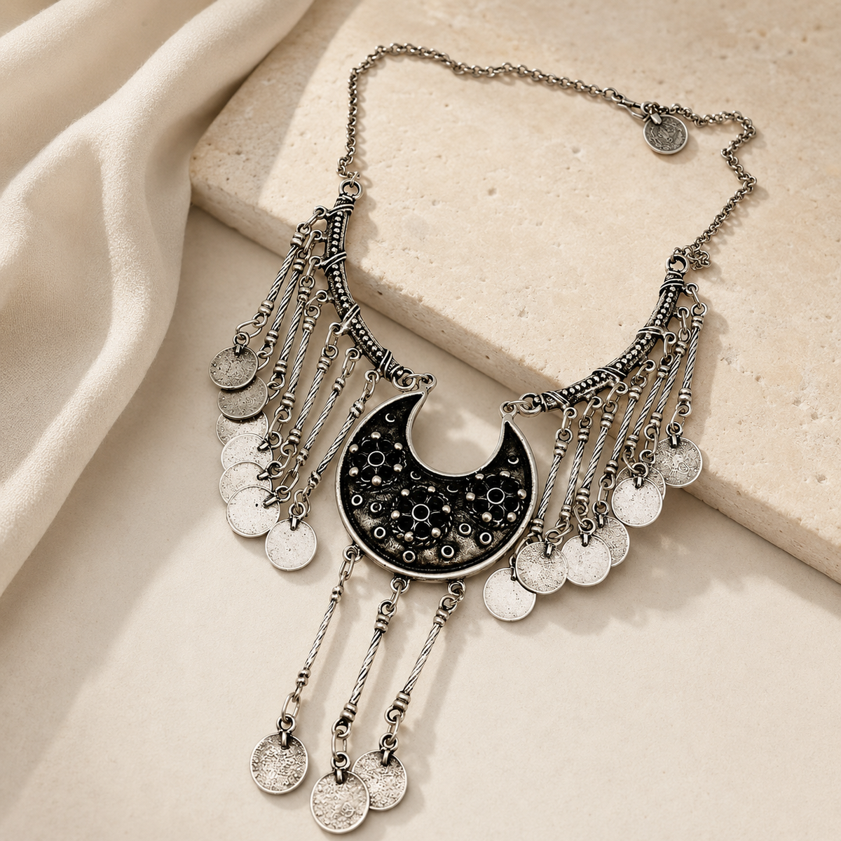 Silver-tone statement necklace with fringe chains and coin charms.