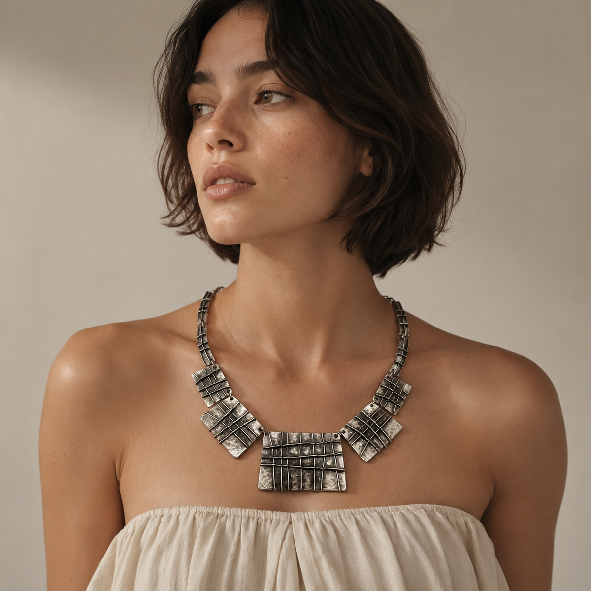Silver-tone statement necklace with multiple grid-patterned plaques.