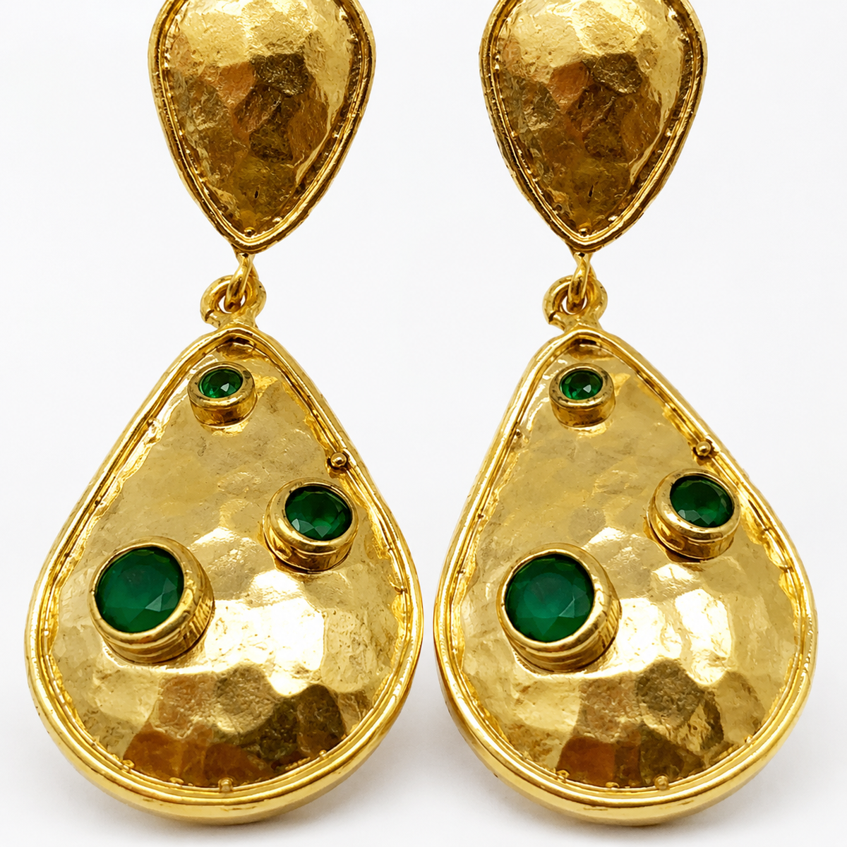 Close view of textured gold-plated earrings with green stone details.