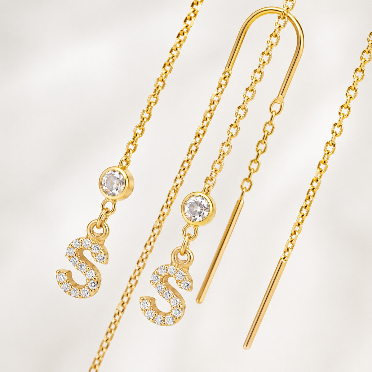 Gold-tone initial dangle earrings with a delicate chain silhouette.
