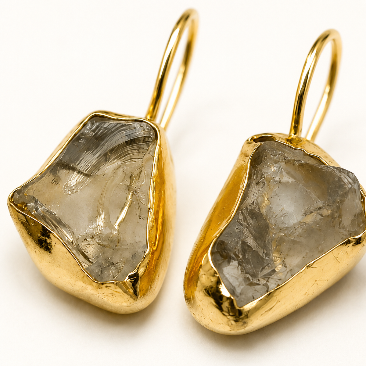 Close-up of raw amethyst stones in a gold-plated drop earring setting.
