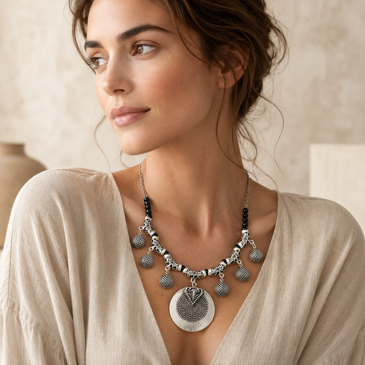 Statement necklace with black beads and a silver-toned medallion pendant.