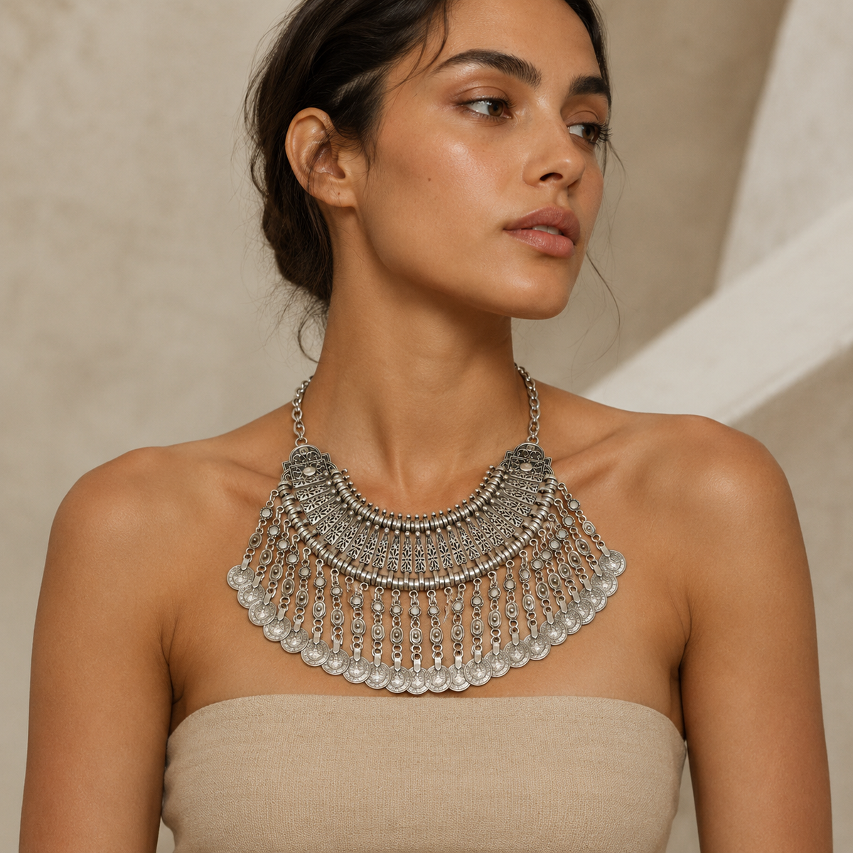 Statement necklace with a bold silver-tone fringe silhouette and coin elements.