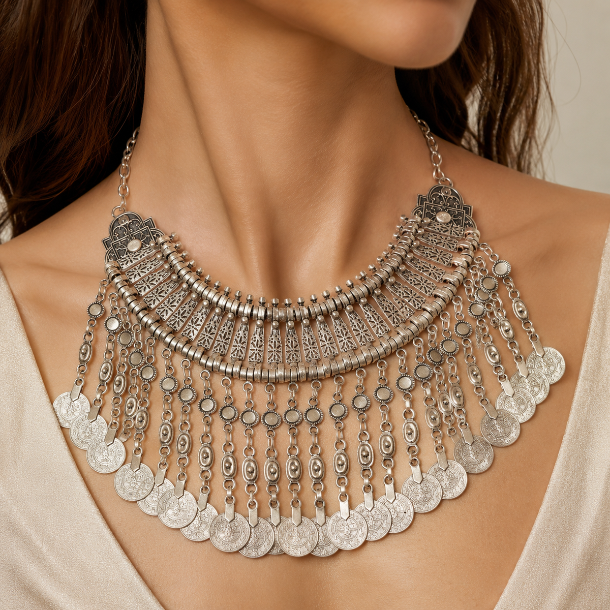 Silver-tone statement necklace with a wide layered fringe design and coin details.