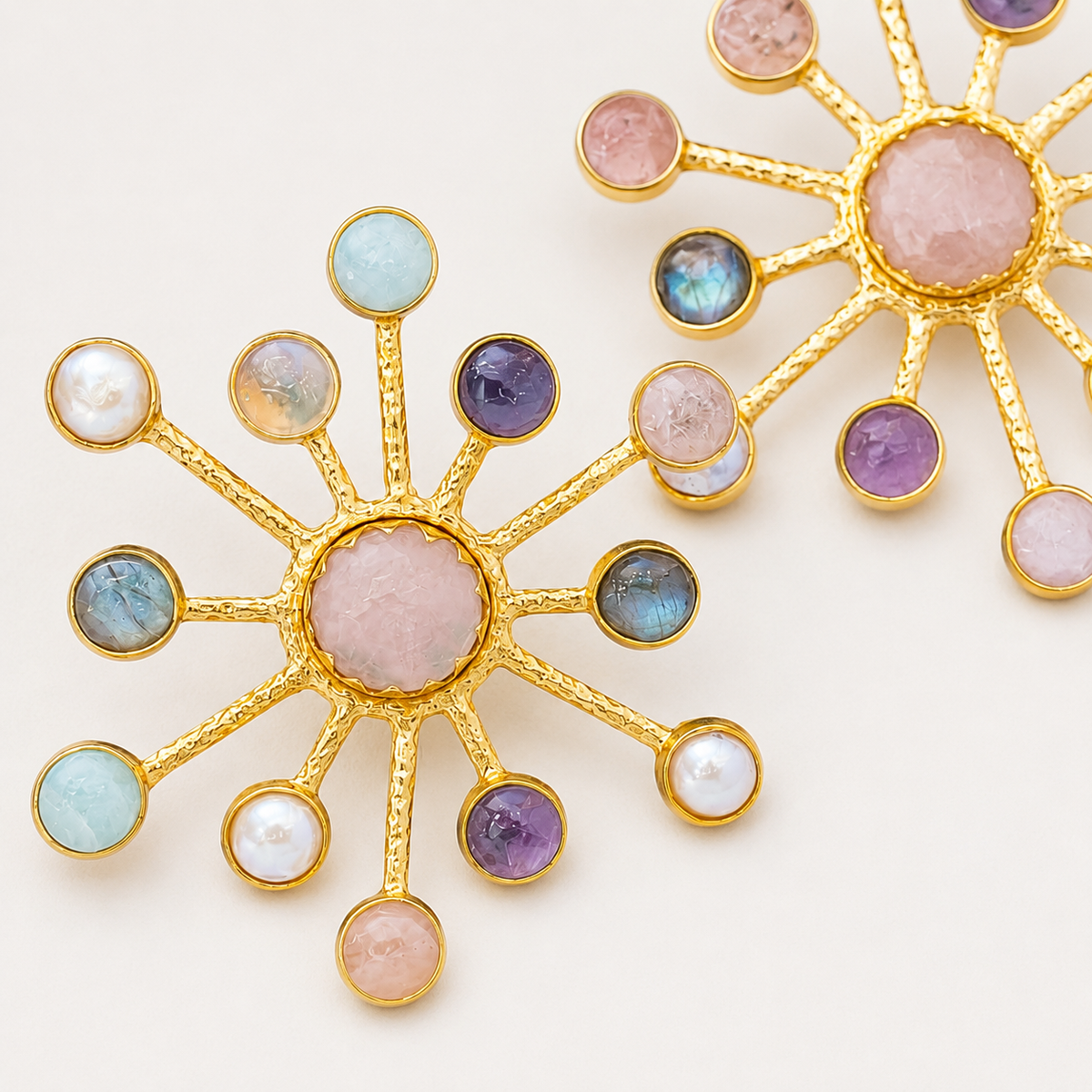 Close-up view of starburst earrings with multicolor gemstone-style accents and gold-plated edges.