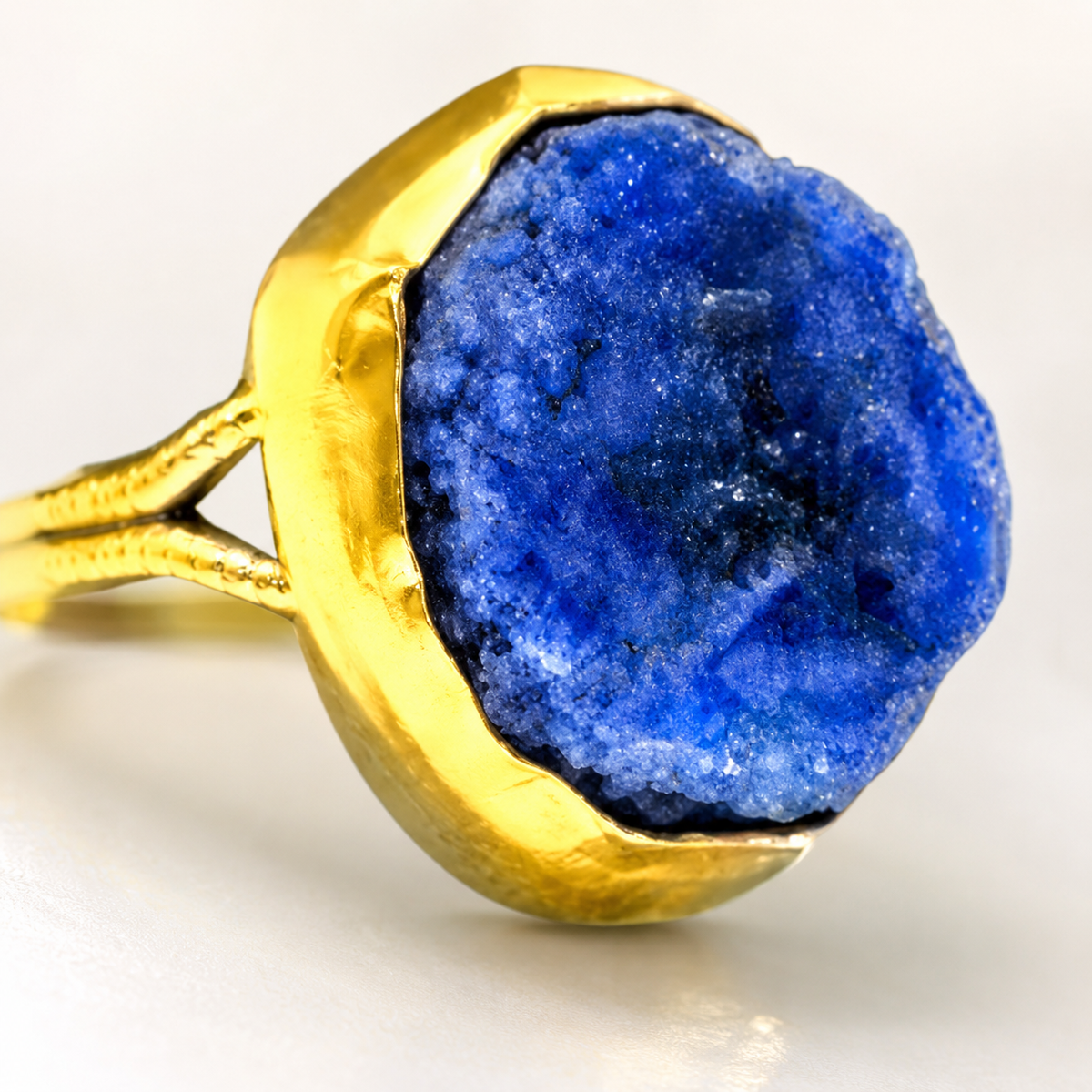 Close view of the raw lapis lazuli stone and gold-plated setting.