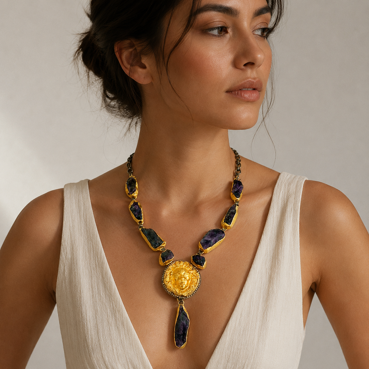 Purple raw stone statement necklace with a bold gold-tone center pendant.