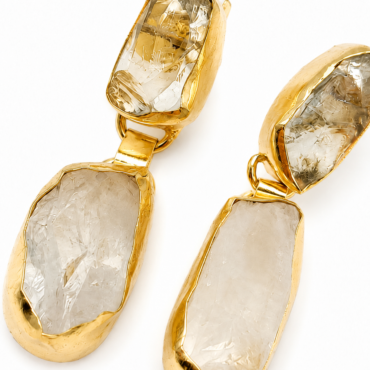 Close view of gold-plated earrings with round pearl-inspired details.
