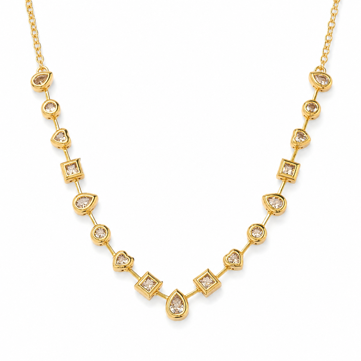 Gold-tone station necklace with mixed shape clear stones on a white background.