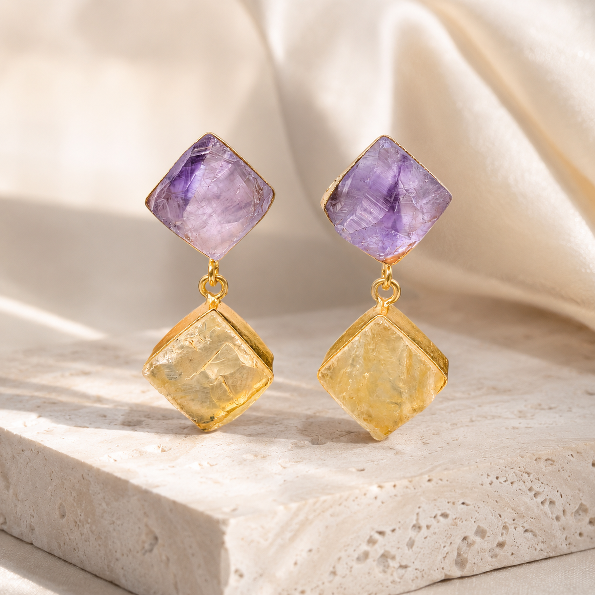 Gold-tone drop earrings with textured purple and golden stones.