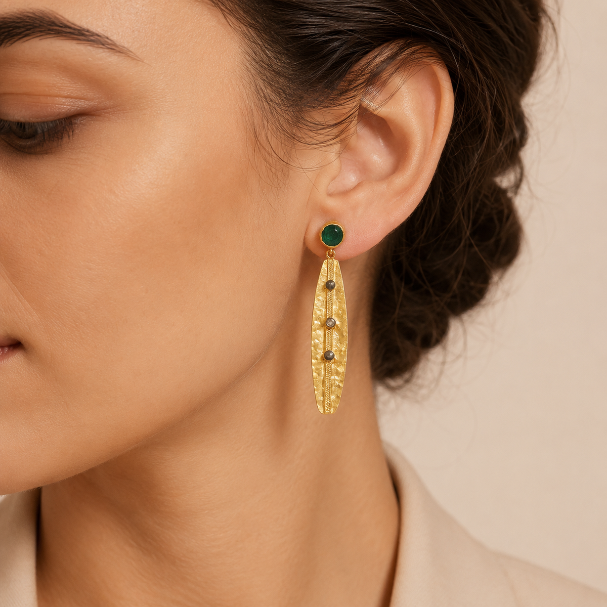Gold-plated drop earrings with olive green stones shown from the front.