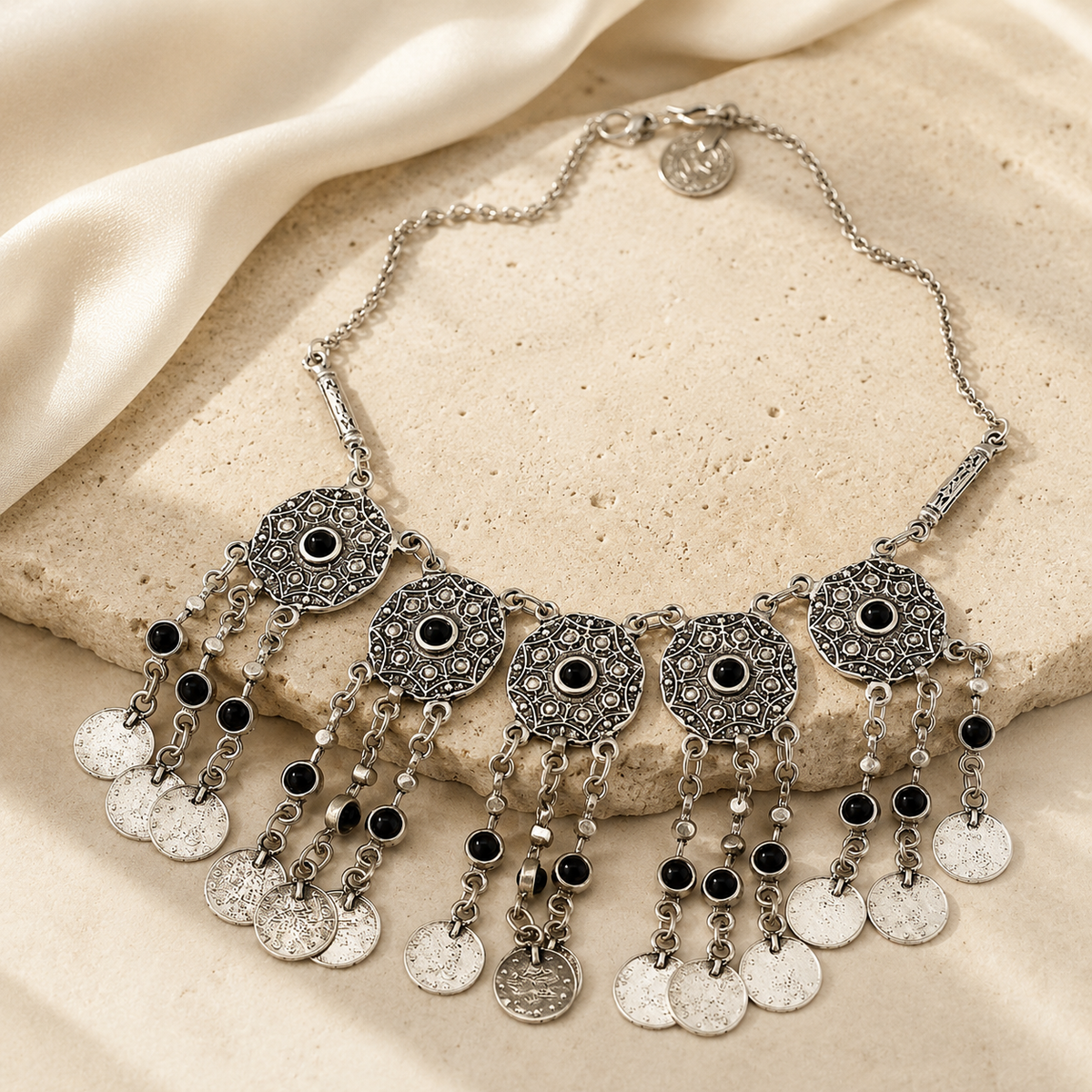 Statement necklace with layered coin fringe and black stone details.