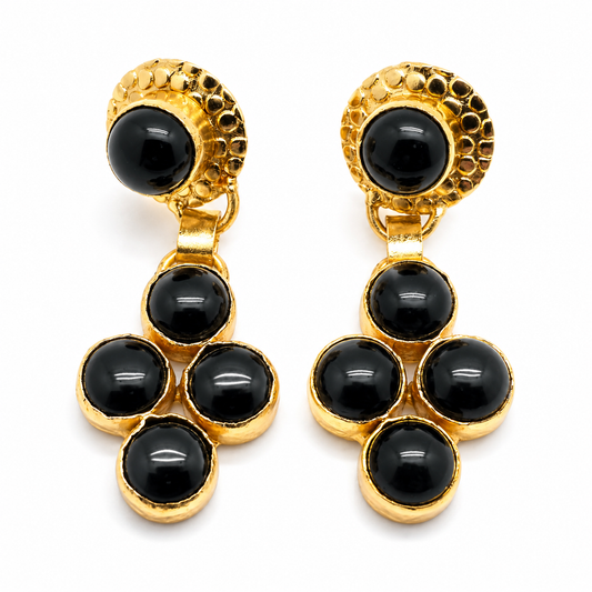 Gold-plated dangle earrings with glossy black onyx stones in a sculptural drop design.