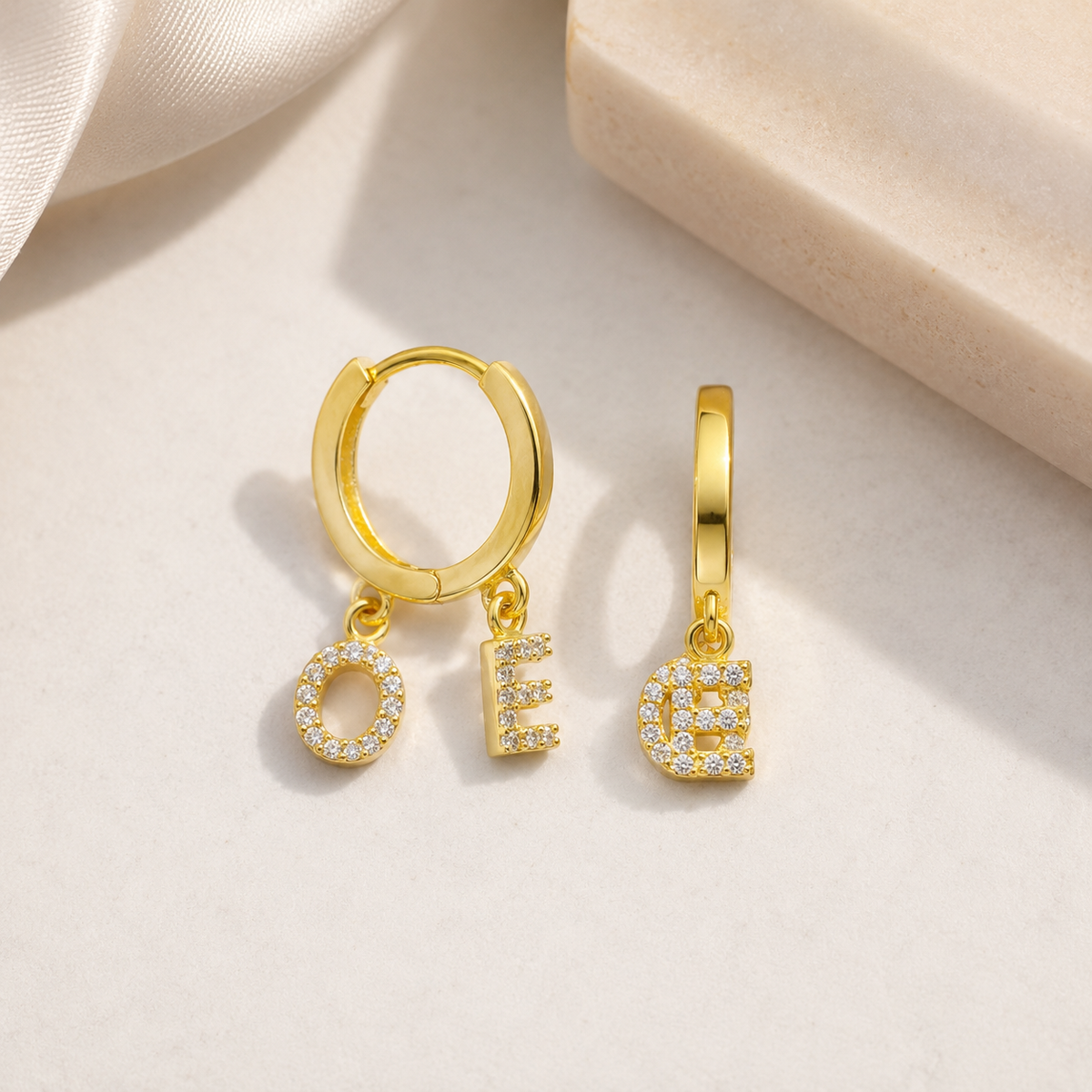 Personalized gold-tone hoop earrings with CZ letter charms.