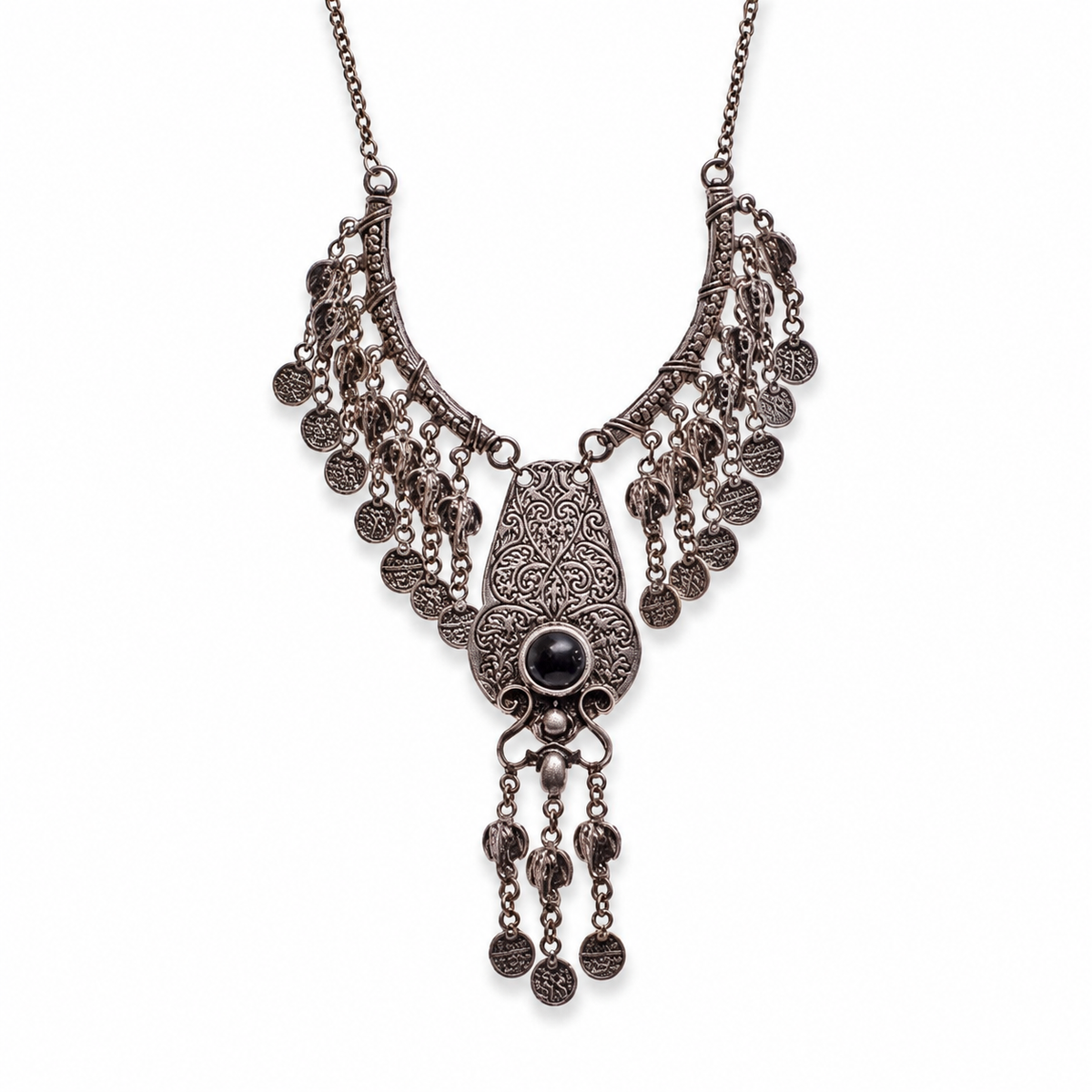 Silver-tone necklace with an ornate filigree pendant, red stone center, and coin fringe.