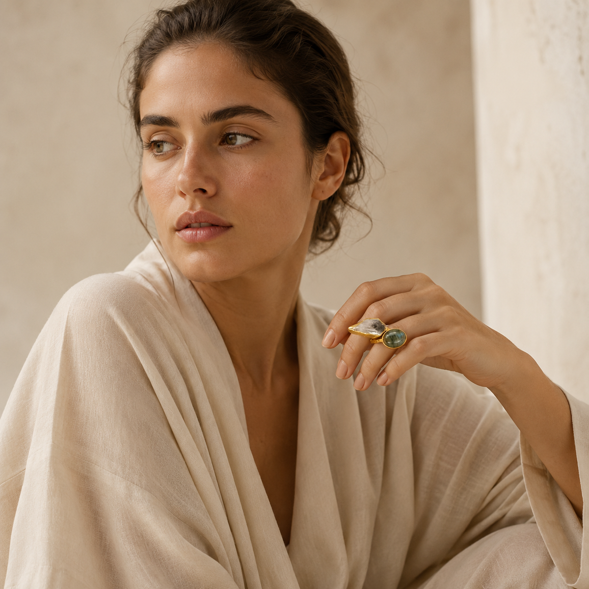 Gold-plated ring featuring a clear stone and a dark green-gray stone.