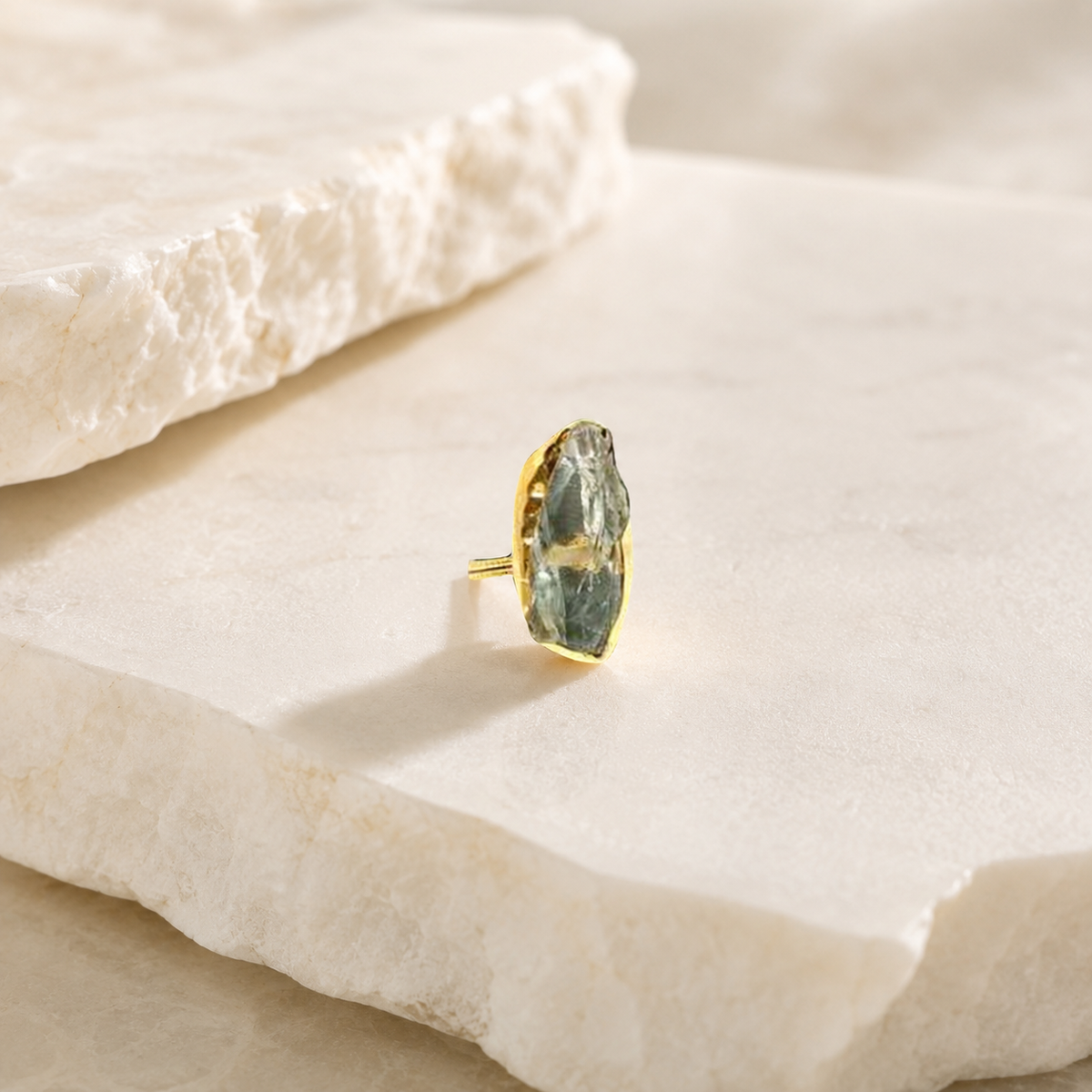 Side angle of a raw green amethyst statement ring with gold-plated metal.