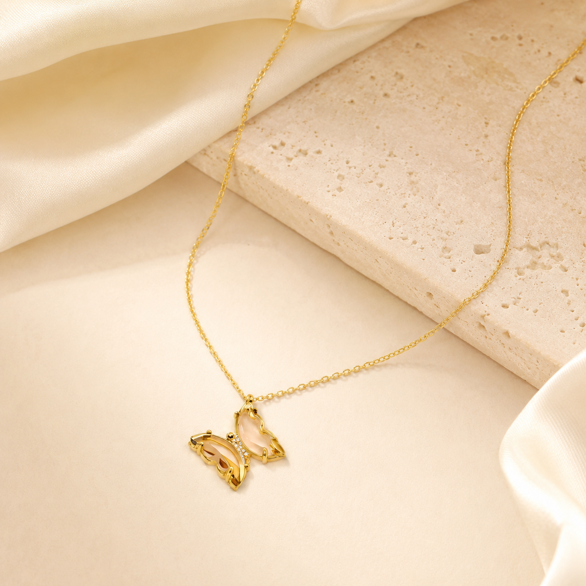 Pink glass butterfly pendant necklace styled on a white background.