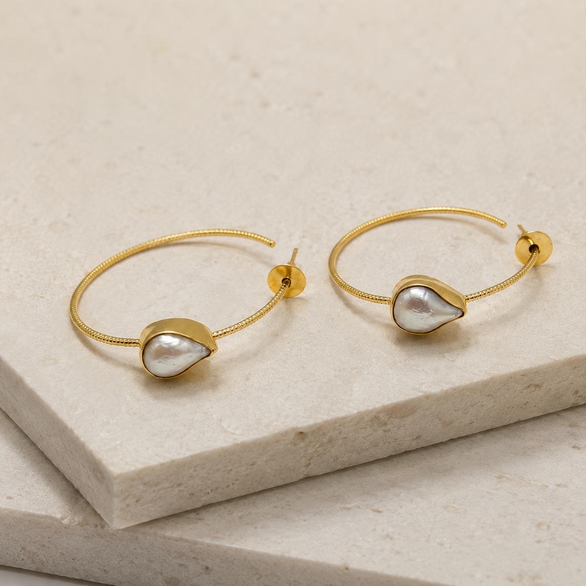 Angled view of teardrop earrings with a gray rutilated quartz look.