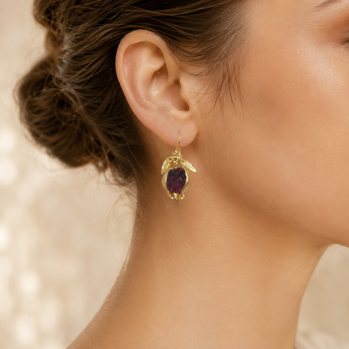 Gold-plated drop earrings with deep red stone centers.