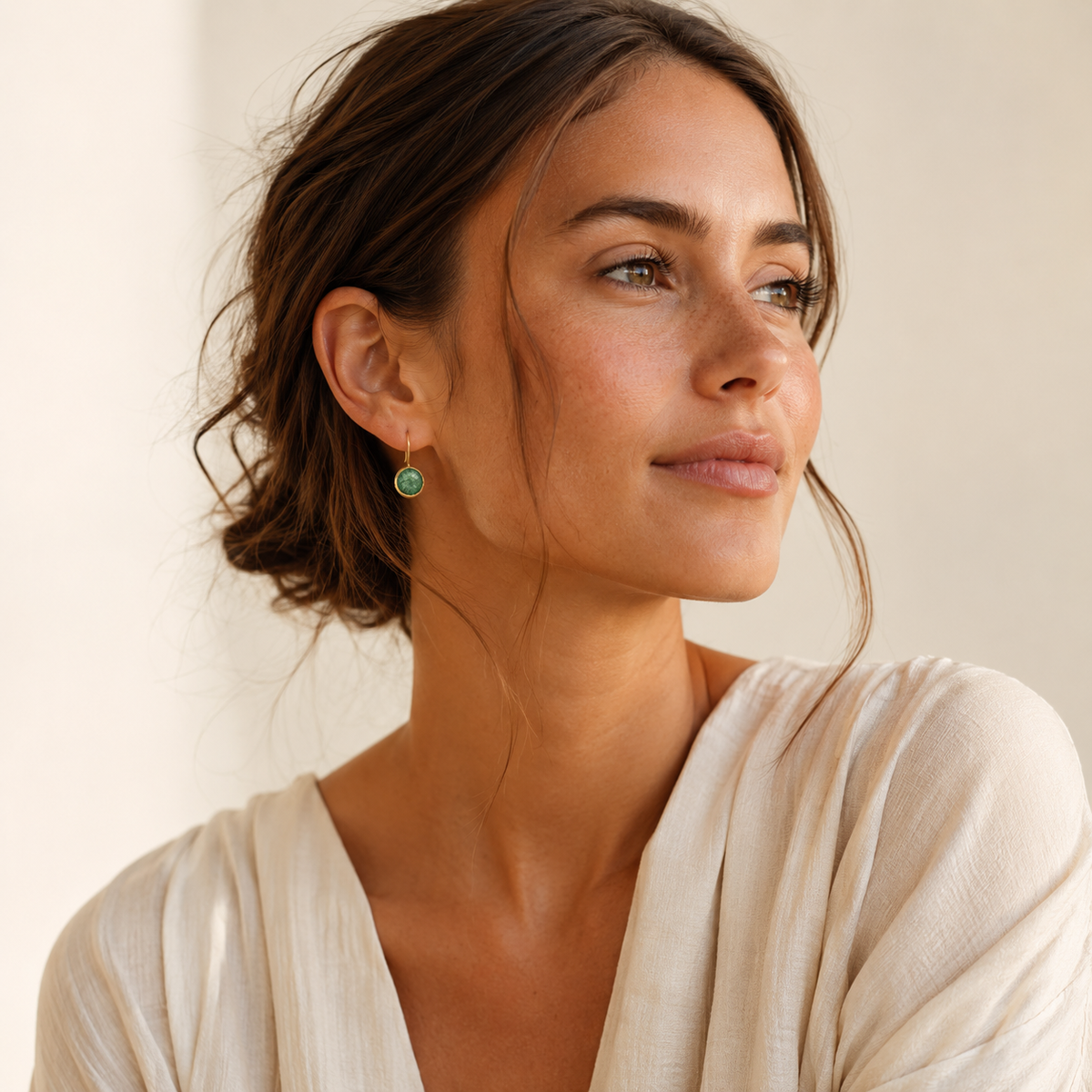 Gold-plated earrings with round green stones and a delicate drop shape.