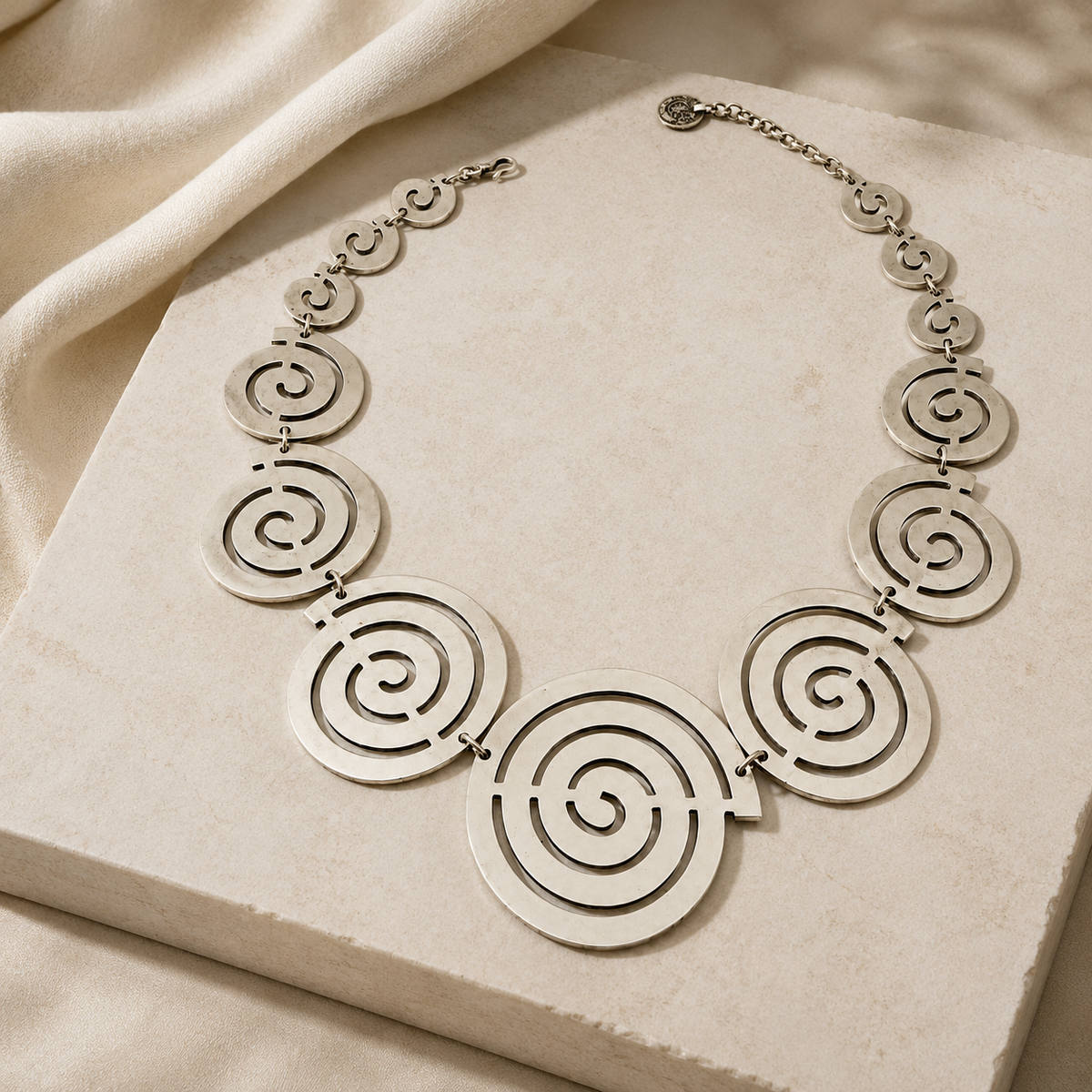 Spiral circle necklace with sculptural round pendants in a gold-tone finish.