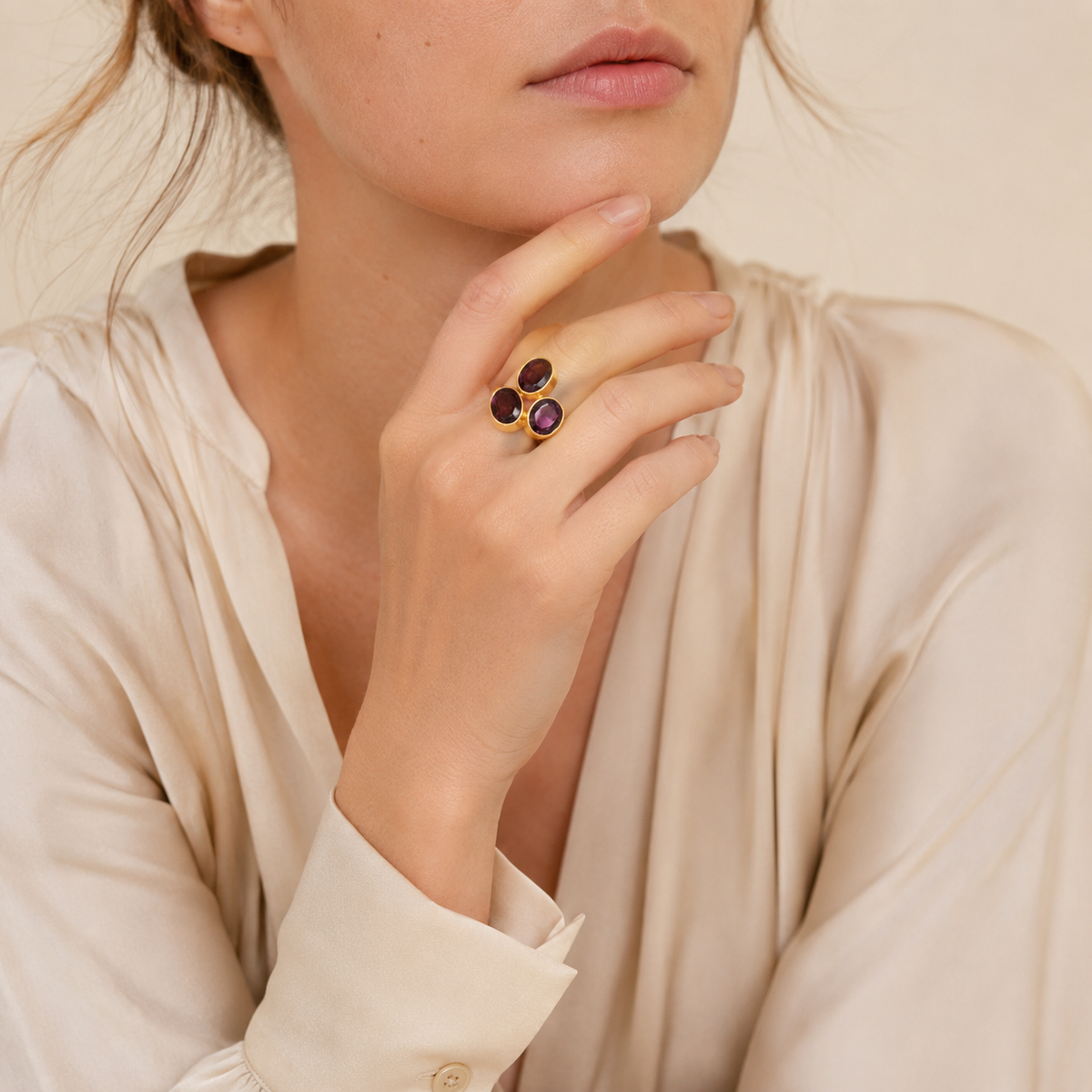Statement ring with three oval purple stones and a gold finish.