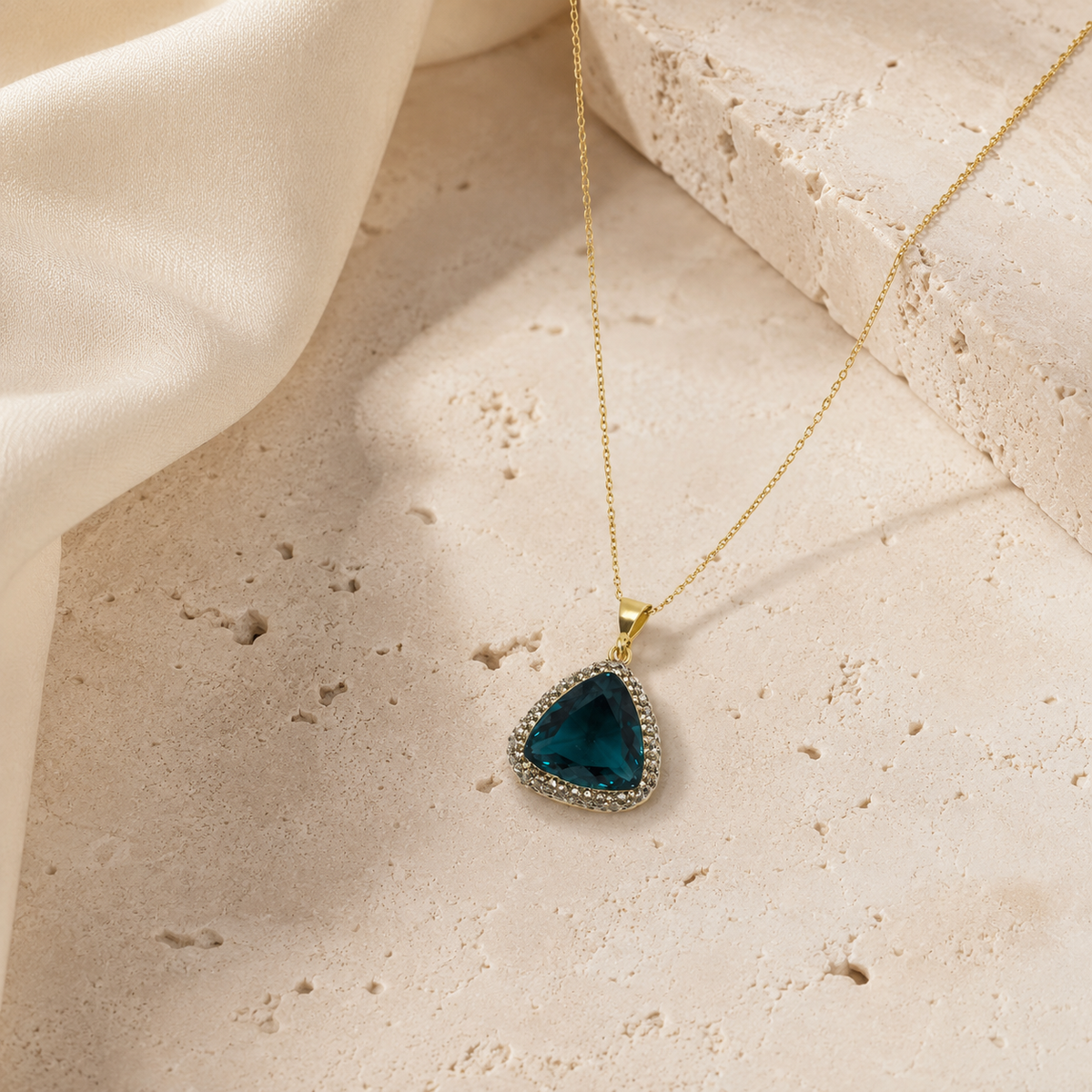 Gold-tone pendant necklace with a deep green triangle center.