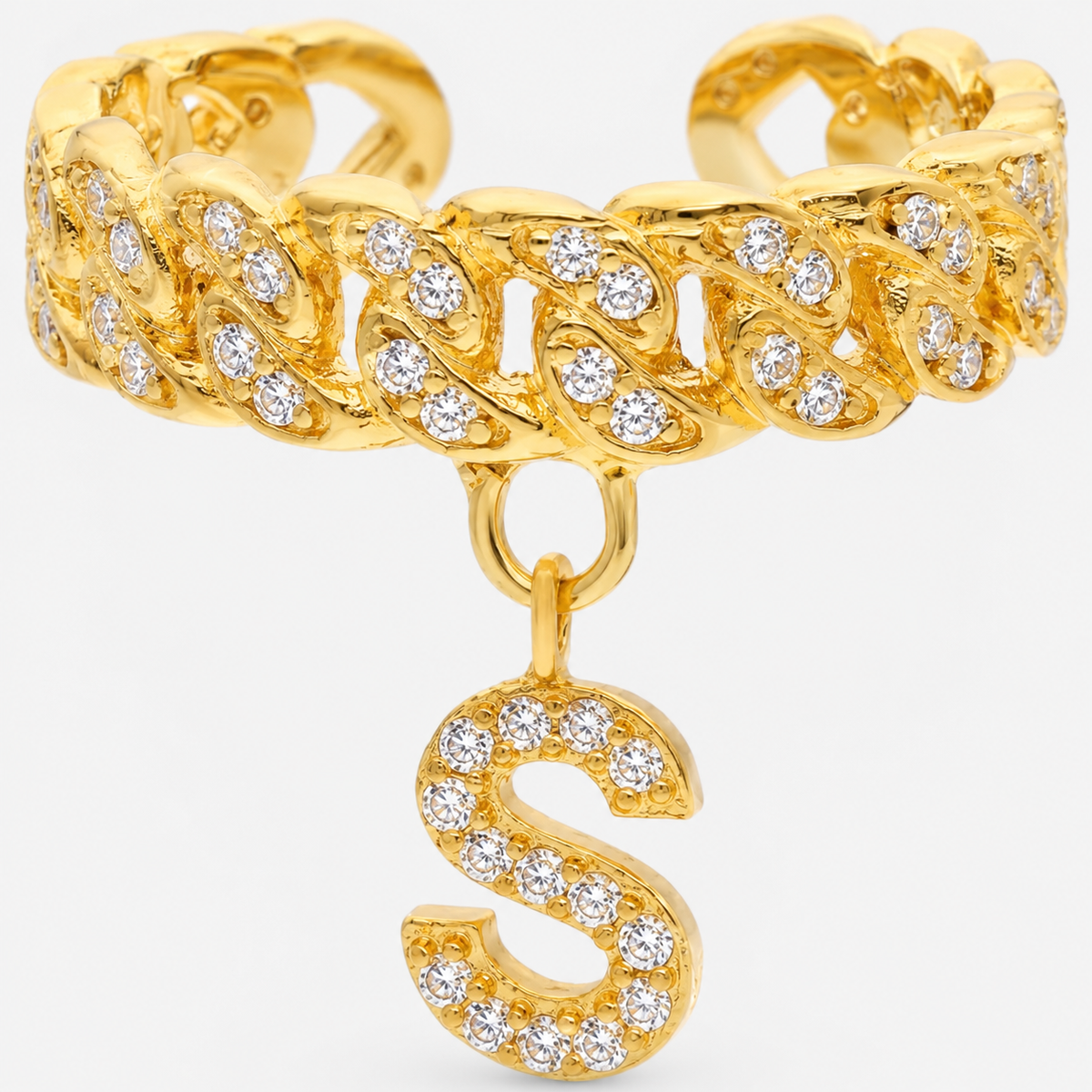 Close-up of a gold-tone cuff ring with CZ accents and a dangling letter charm.
