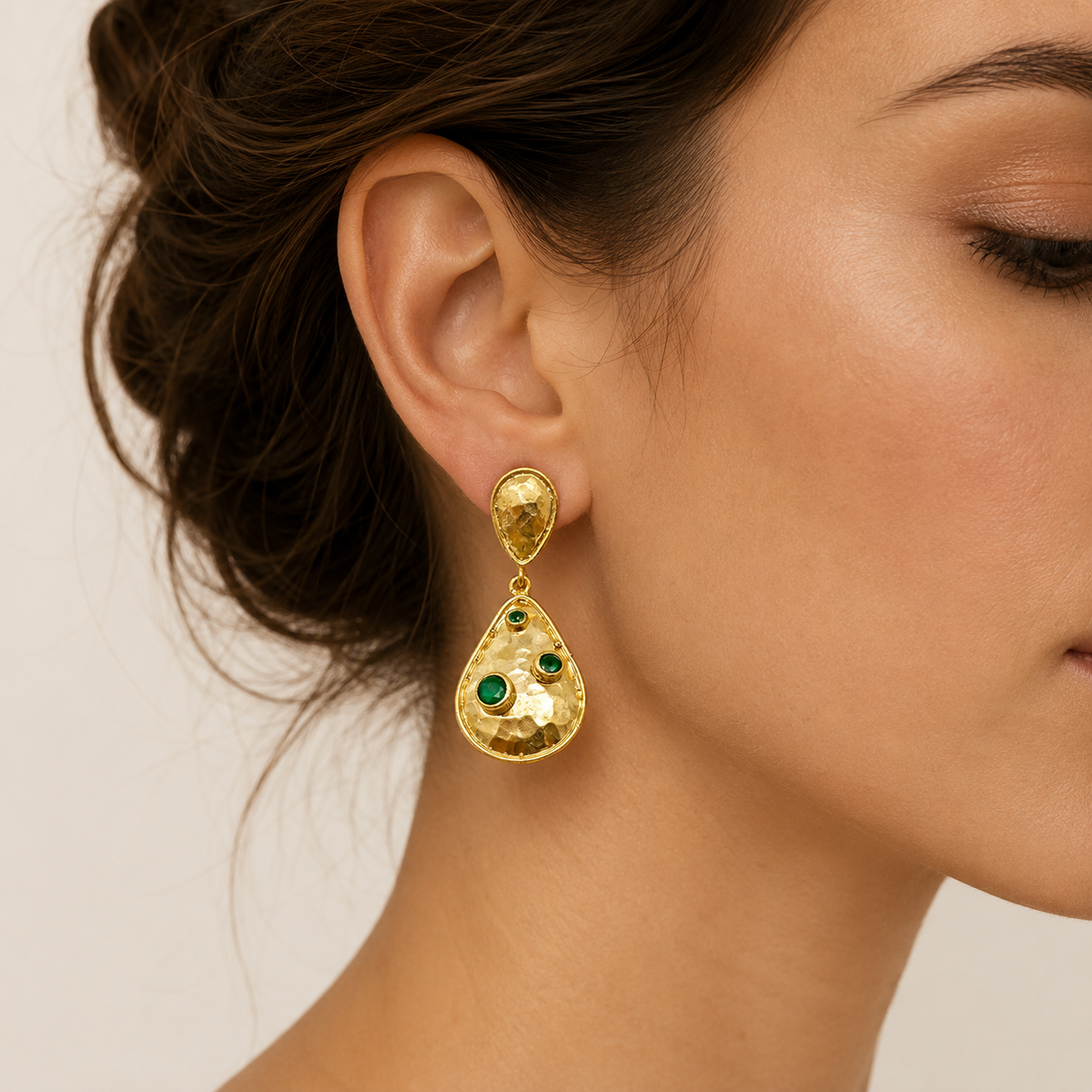 Pair of hammered gold-plated drop earrings with green stones.