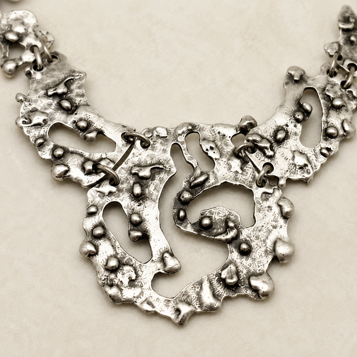 Close view of the textured silver-tone pendant and chain links.