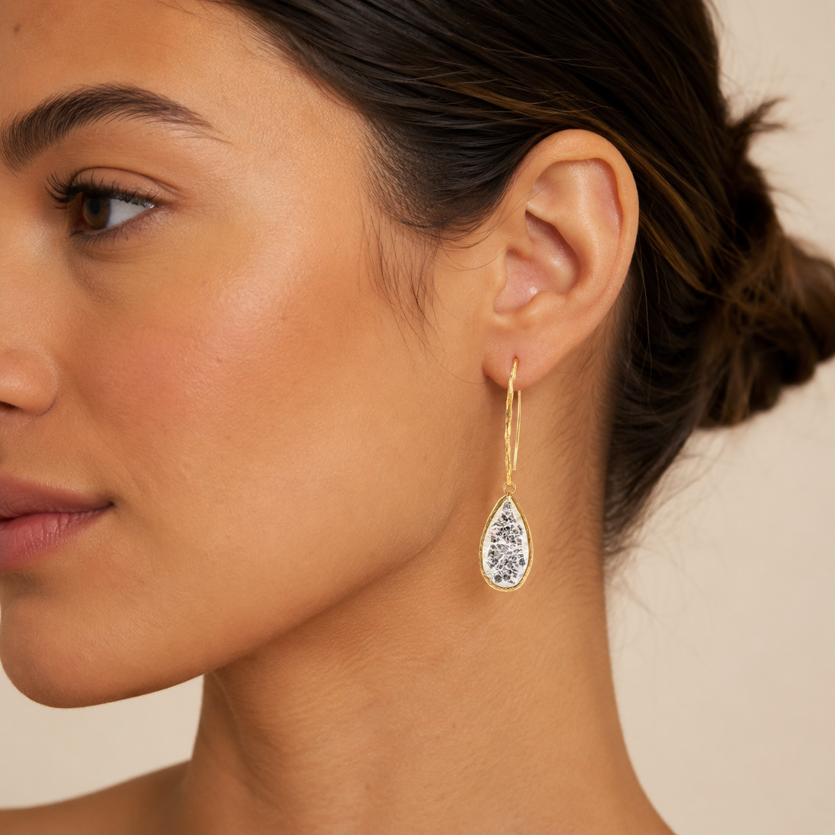Gold-plated hook earrings with teardrop-shaped cracked crystal pendants.